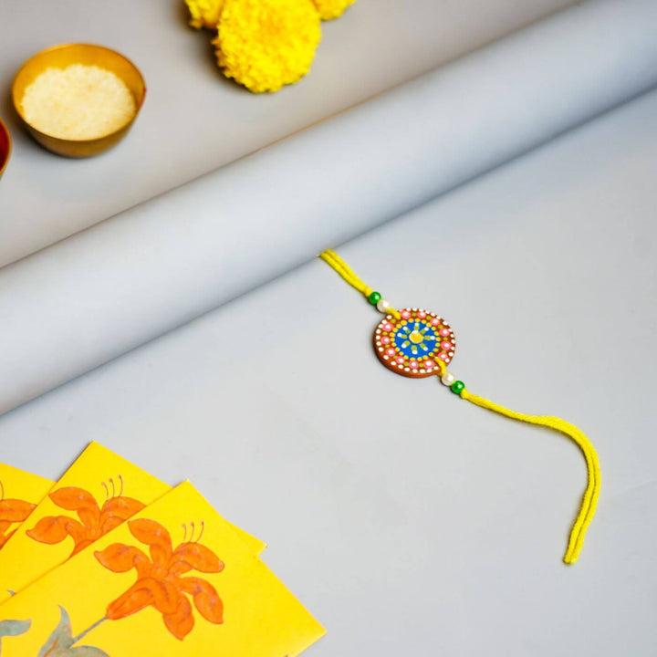 Handpainted Terracotta Rakhi Mug Set With Roli Chawal - Flat lay with ceremonial items