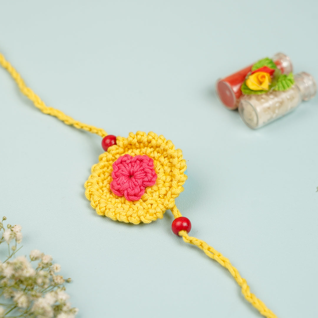 Handmade Crochet Round Mini Floral Rakhi With Roli Chawal - Flat lay with decorative props (5)