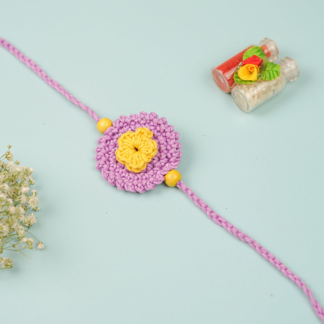 Handmade Crochet Round Mini Floral Rakhi With Roli Chawal - Flat lay with decorative props