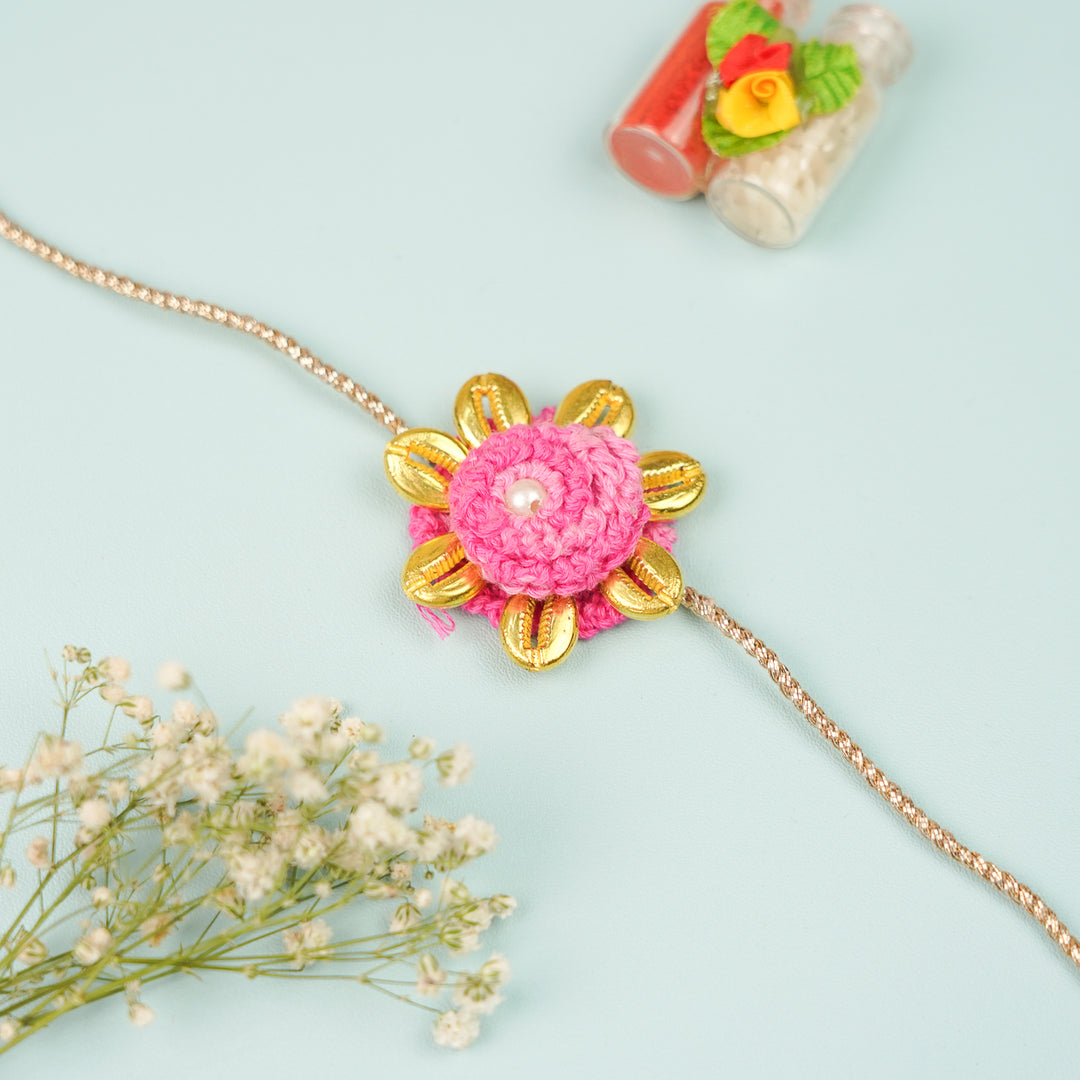 Handmade Crochet Cowry Beaded Floral Rakhi With Roli Chawal - Front View with Flowers and Bottles (8)