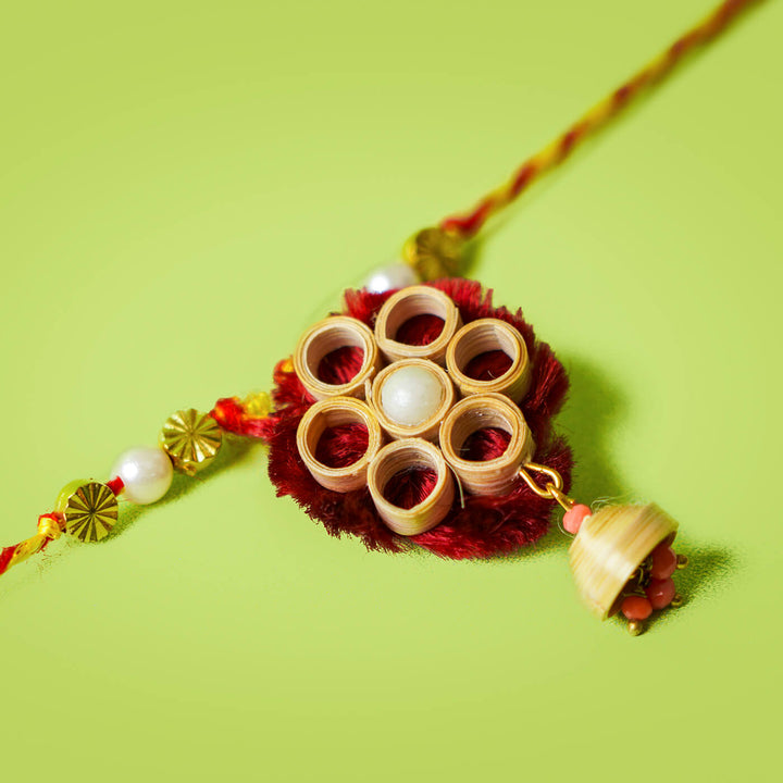 Ecofriendly Bamboo Lumba Rakhi With Green Quilled Jhumki Pearl - Close-up of woven Rakhi centerpiece