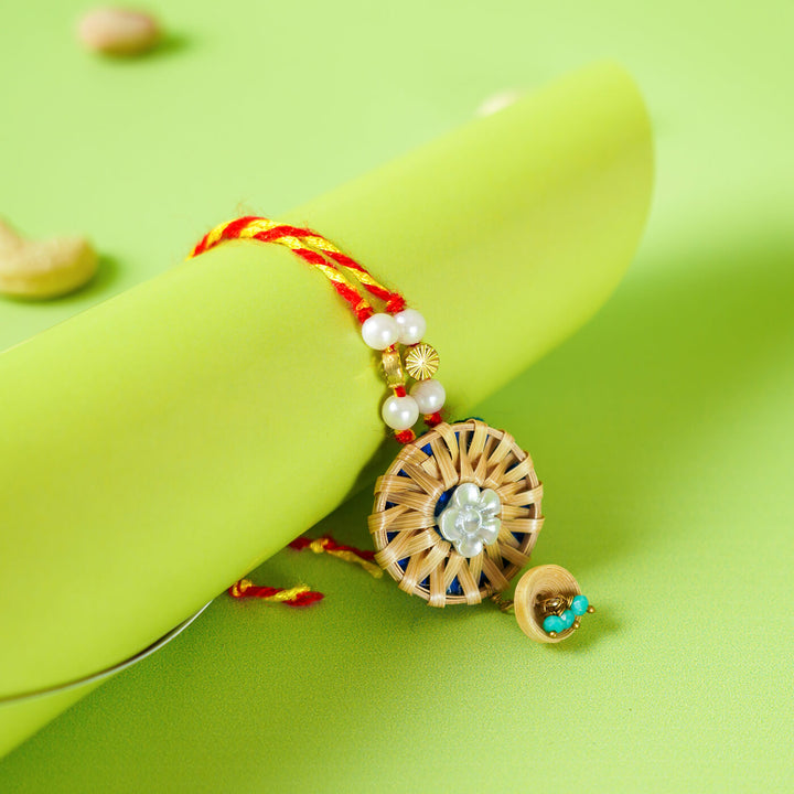Ecofriendly Bamboo Lumba Rakhi With Green Quilled Jhumki Pearl - Rakhi wrapped around green cylinder