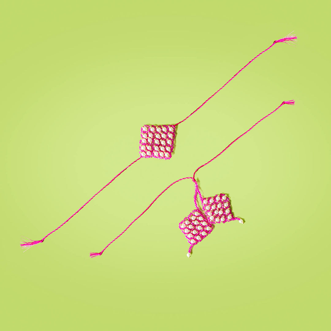 Handcrafted Bhaiya Bhabhi Round Rakhi Set Blue - Pink Beaded Pair on Green Background