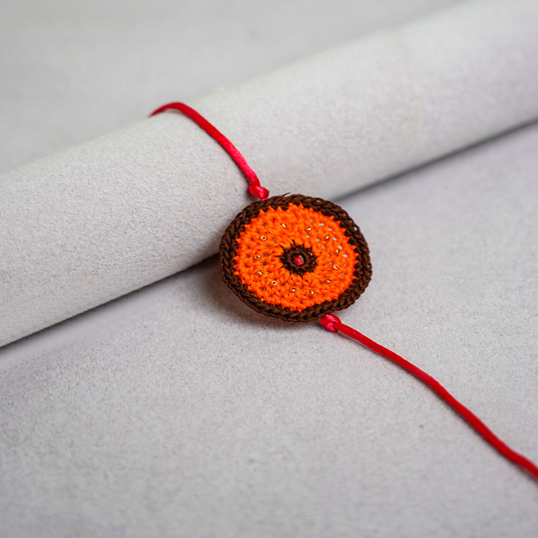 Handcrafted Mandala Crochet Rakhi With Roli Chawal For Kids 2 - Orange Rakhi Close-up Front View