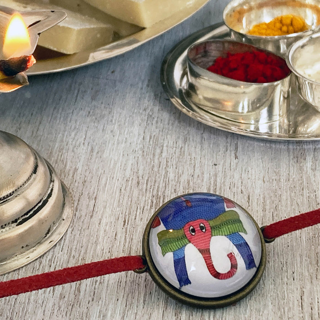 Gond Elephant Handcrafted Folkart Rakhi - Close-up with Ritual Items