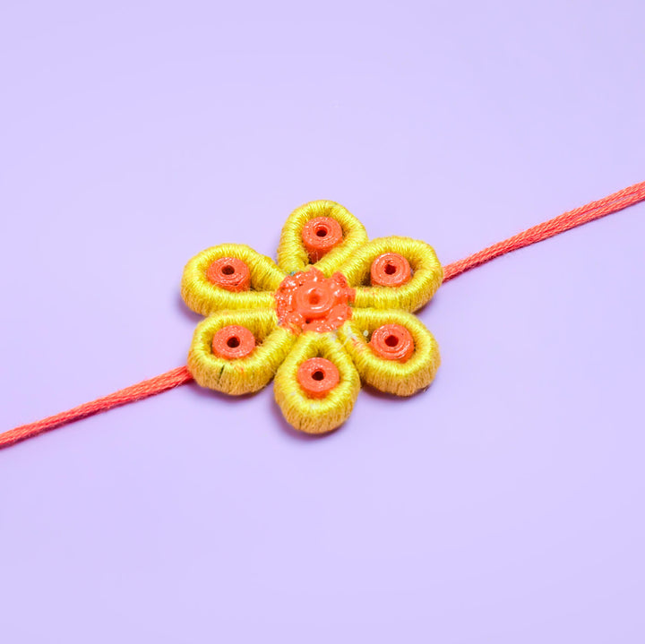 Paper Mache Rakhi Yellow Blossom - Rakhi Flower on Purple Background