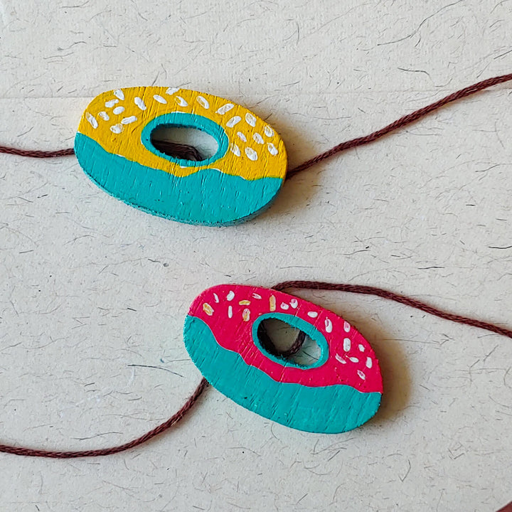 Handpainted Wooden Rakhi Set Of 2 Donuts - Top View of Donut Design Rakhi