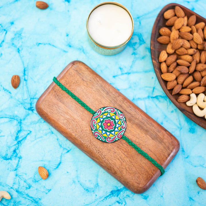 Hand Painted Seed Rakhi Green - Mounted on Dark Wooden Display Block