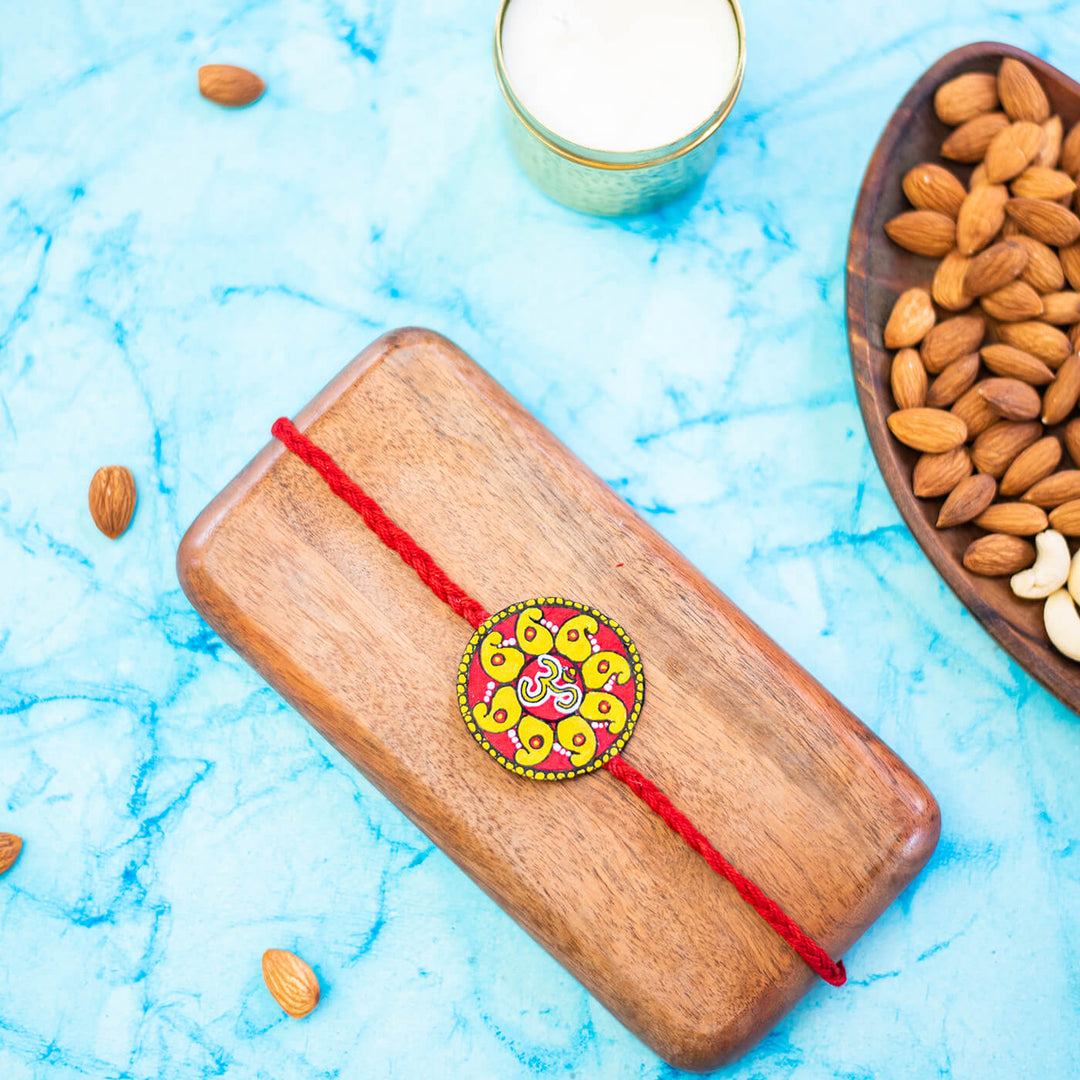 Hand Painted Seed Rakhi Red - Styled Scene with Props