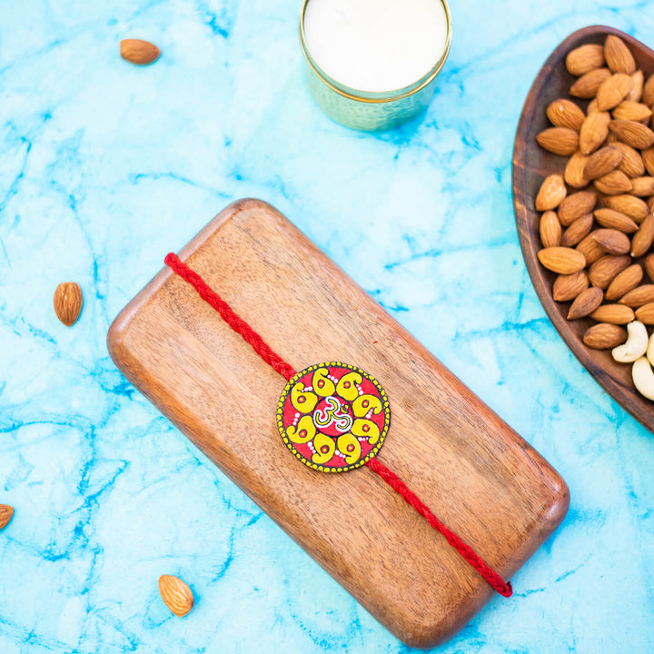 Hand Painted Seed Rakhi Red - Styled Scene with Props