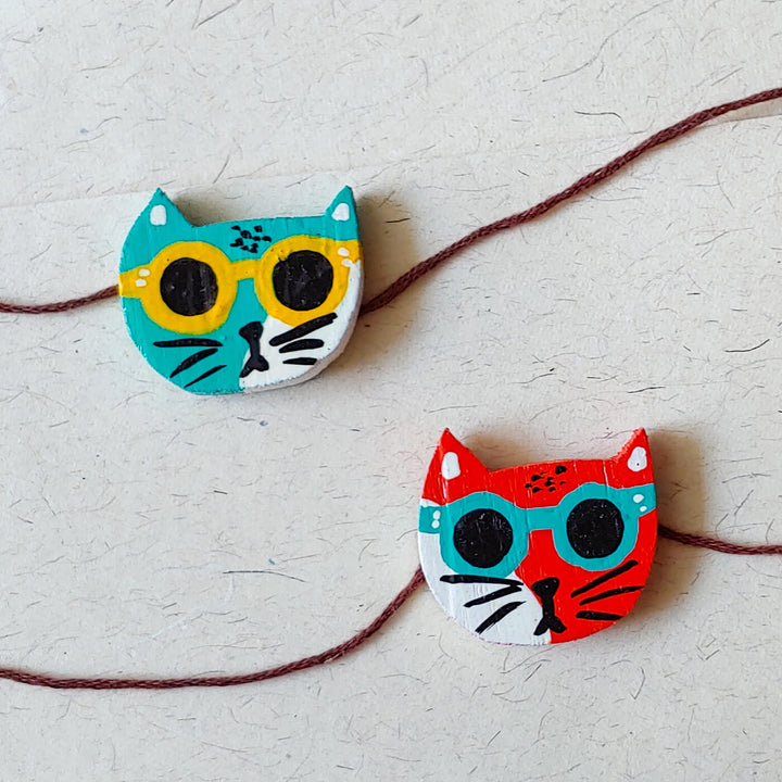 Handpainted Wooden Rakhi Set Of 2 Mini Birds - Close-up of cat face designs