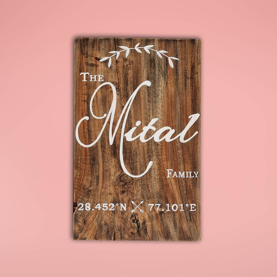 Rustic Wood Hand Painted Family Name Plate With Co Ordinates - Front View on Pink Background